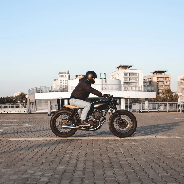 Motociclista andando em uma motocicleta no estacionamento na cidade — Fotografia de Stock