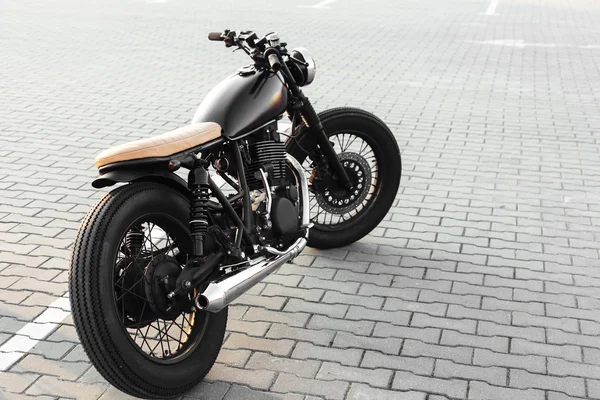 Vintage motorcycle in parking lot during sunset