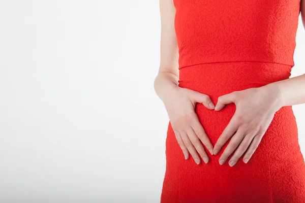 Zwangere jonge vrouw met hart teken — Stockfoto