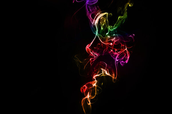 Abstract colorful smoke on the black background in studi