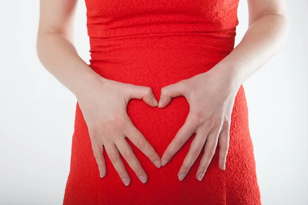 Młoda kobieta w ciąży z serca znak — Zdjęcie stockowe