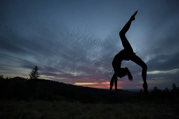 Practicante de yoga durante la puesta del sol — Foto de Stock