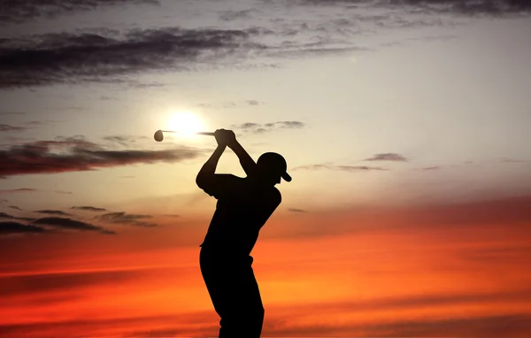 Παίχτης του γκολφ, παίζοντας γκολφ κατά τη διάρκεια του ηλιοβασιλέματος στην εκδήλωση του διαγωνισμού — Φωτογραφία Αρχείου