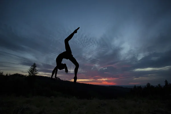 Practicante de yoga durante la puesta del sol — Foto de Stock