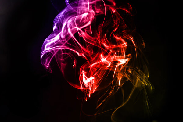 Abstract colorful smoke on the black background in studi