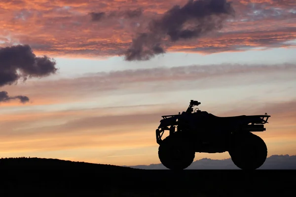Silhouette ATV or Quad bike in the sunset. Holiday exploration concept with silhouette of quad bike