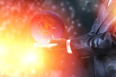 Sırtında altın toprak taşıyan bir iş adamı, çevresel kavram, NASA tarafından desteklenen bu görüntünün elementleri.