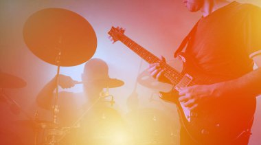 Konser sırasında canlı performans, konser. Gitarist ve davulcu siluetleri