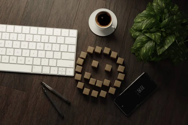 キーボードの机の上に幸せな感情のアイコンのイラストと木製のキューブ コーヒー スマートフォン ロイヤリティフリーのストック画像