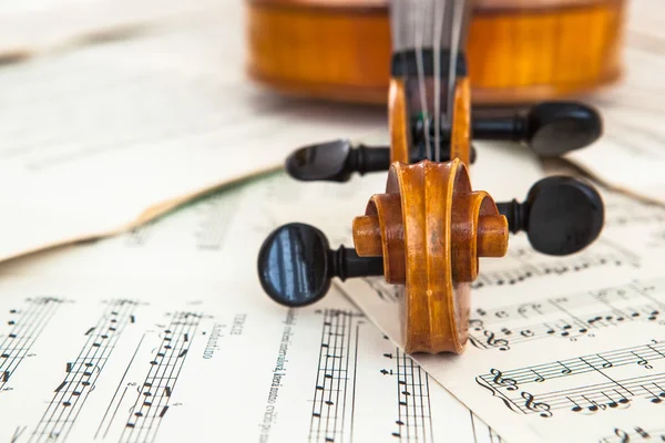 Oude viool liggend op het blad van de muziek — Stockfoto