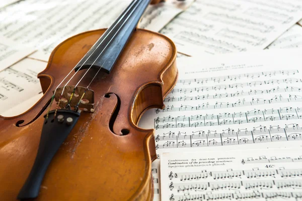 Oude viool liggend op het blad van de muziek — Stockfoto