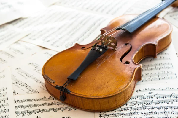 Vecchio violino sdraiato sullo spartito della musica — Foto Stock