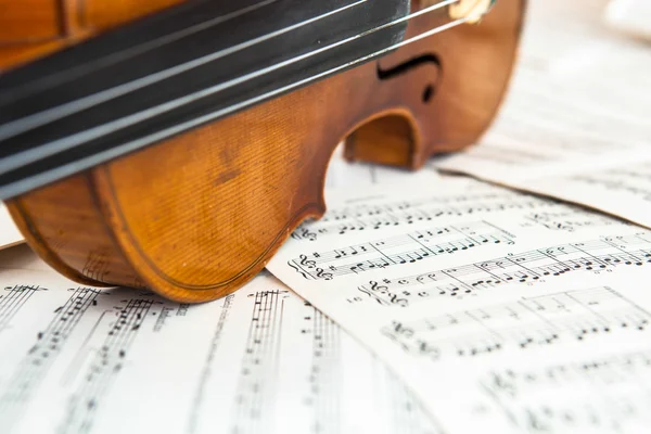 Old violin lying on the sheet of music — Stock Photo, Image