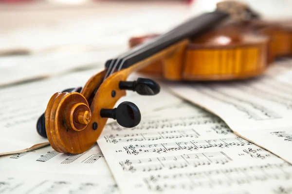 Old violin lying on the sheet of music — Stock Photo, Image