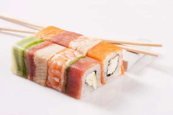 Японские суши из морепродуктов, рулон и палочка для еды на белой спине — стоковое фото