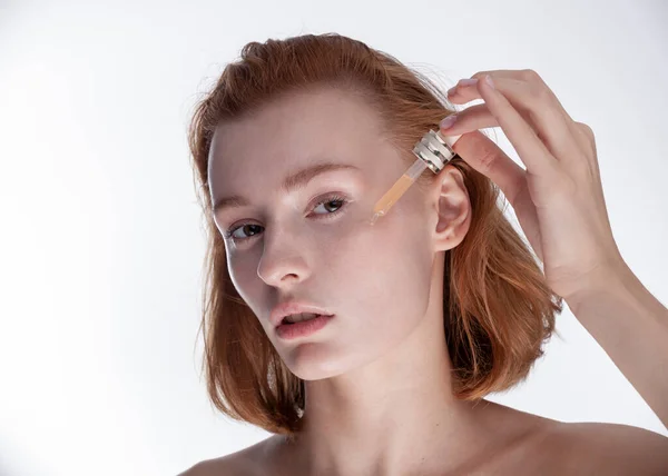 Beyaz arka planda cilt bakım kozmetiği olan kız