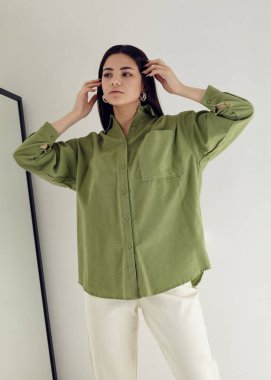 Yeşil gömlekli güzel esmer ve beyaz pantolonlu açık arkaplan