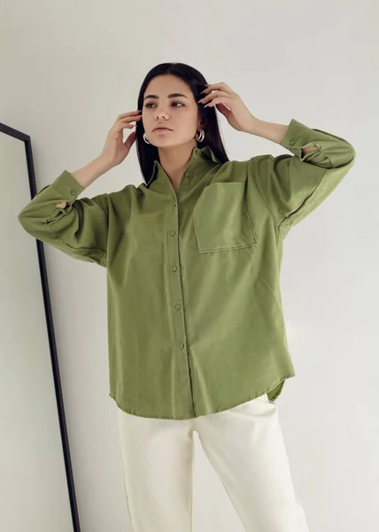 Yeşil gömlekli güzel esmer ve beyaz pantolonlu açık arkaplan