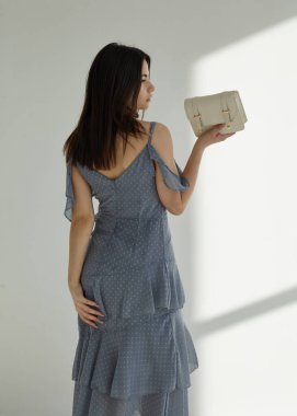 Beyaz arka planda, esmer mavi bahar elbisesi içinde güzel.