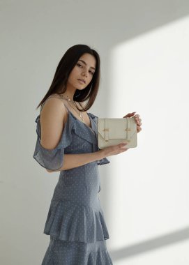 Beyaz arka planda, esmer mavi bahar elbisesi içinde güzel.