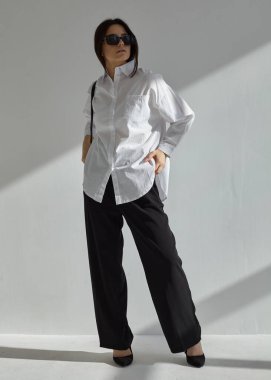 Güneş gözlüklü ve takım elbiseli güzel bir esmerin portresi.