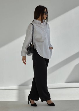 Güneş gözlüklü ve takım elbiseli güzel bir esmerin portresi.