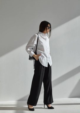 Güneş gözlüklü ve takım elbiseli güzel bir esmerin portresi.