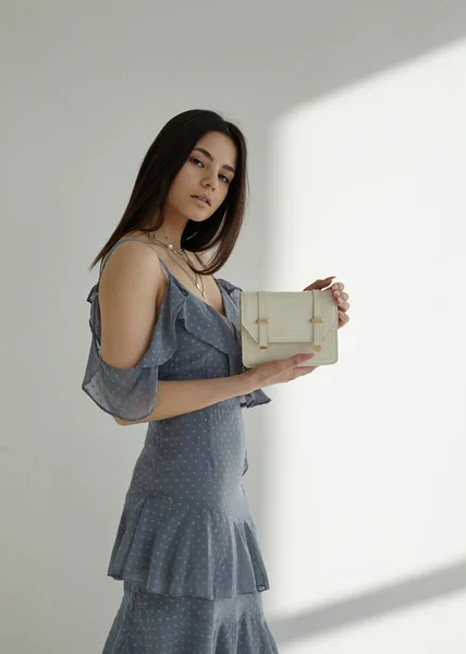 Beyaz arka planda, esmer mavi bahar elbisesi içinde güzel.