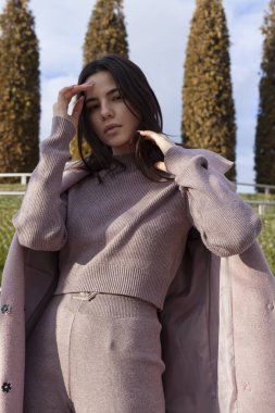 Pembe ceketli ve takım elbiseli güzel bir esmer.