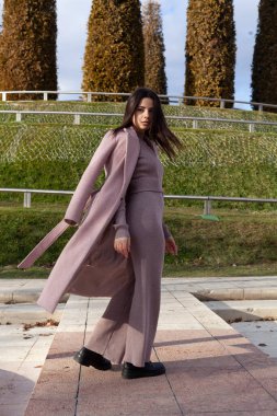 Pembe ceketli ve takım elbiseli güzel bir esmer.