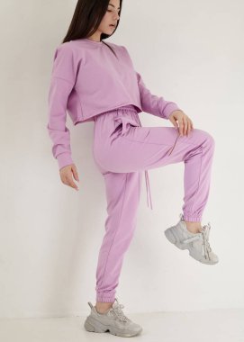 Açık arkaplanda parlak pembe bir bahar elbisesi içinde güzel bir esmer.