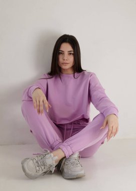 Açık arkaplanda parlak pembe bir bahar elbisesi içinde güzel bir esmer.