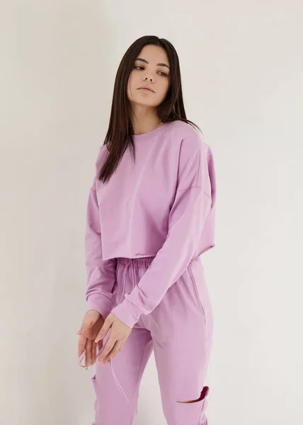 Açık arkaplanda parlak pembe bir bahar elbisesi içinde güzel bir esmer.