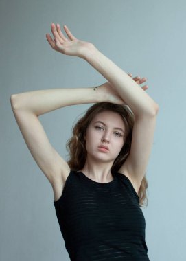 Bahar kıyafetleri içinde güzel bir sarışın açık bir arkaplanda poz veriyor.