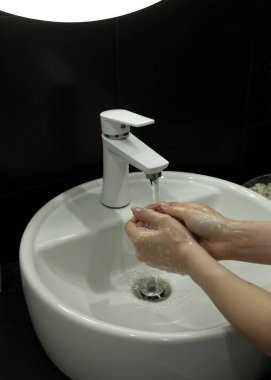 Kız karantina sırasında ellerini iyice yıkıyor.