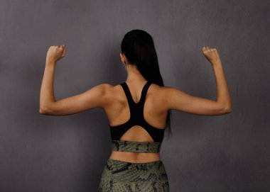 Atletik kız sırt kaslarını gösteriyor