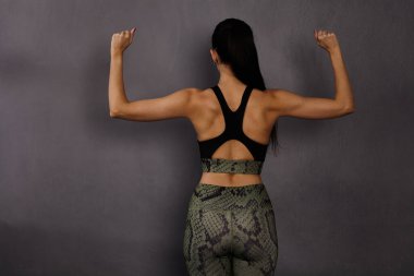 Atletik kız sırt kaslarını gösteriyor