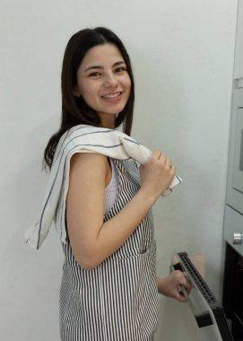 Güzel esmer fırında yemek pişiriyor.