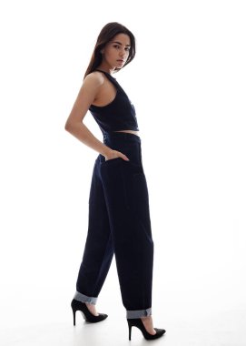 Kot takım elbiseli güzel esmer, beyaz bir arka planda hareket halinde.