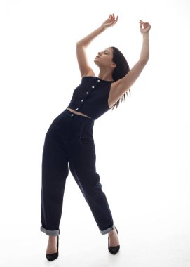 Kot takım elbiseli güzel esmer, beyaz bir arka planda hareket halinde.