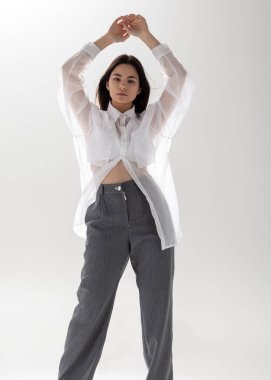 Açık arkaplanda şeffaf gömlekli ve takım elbiseli güzel bir esmer.