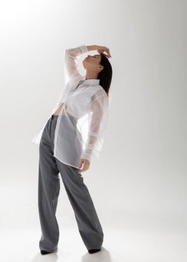 Açık arkaplanda şeffaf gömlekli ve takım elbiseli güzel bir esmer.