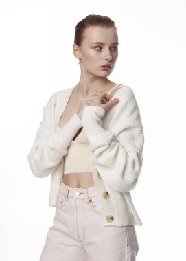 Beyaz yaz süveteri giyen, açık arkaplanda güzel kızıl saçlı bir kızın portresi.