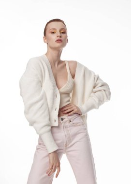 Beyaz yaz süveteri giyen, açık arkaplanda güzel kızıl saçlı bir kızın portresi.