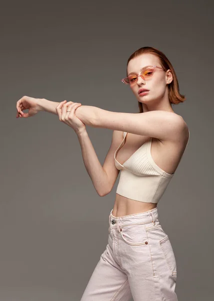 Koyu renk arka planda moda yaz kıyafetleri içinde güzel kızıl kız.