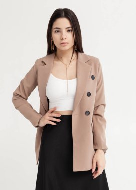 Ceketli güzel bir esmer ve açık arkaplanda yaz kıyafetleri.