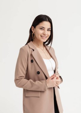 Güzel esmer, ofis elbiseleri içinde gülümsüyor.