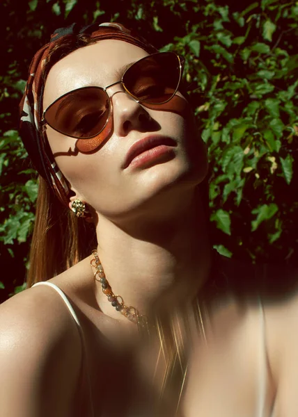 Doğada güneş gözlüklü kızıl saçlı kız.