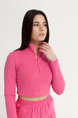 Açık arkaplanda pembe eşofmanlı güzel esmer.