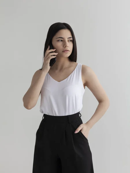 Güzel kız telefonda düşünceli bir şekilde konuşuyor.